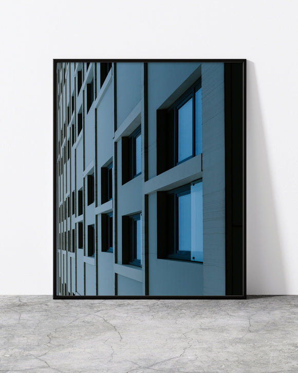 Urban architecture print showcasing a modern facade with symmetrical window frames and deep blue reflections.