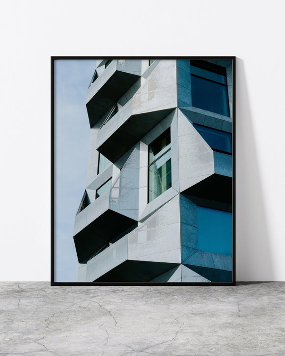Contemporary building wall art with bold, angular design and reflective blue glass details.