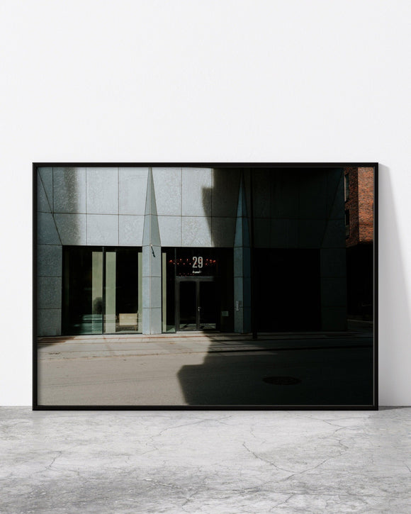 Minimalist urban print featuring a modern building facade with sharp geometric lines and contrasting shadows.