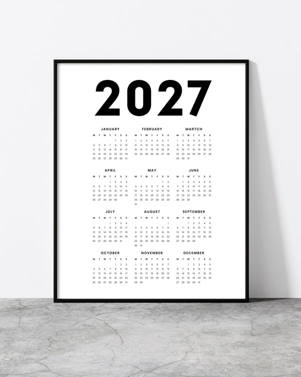 2027 V8 wall calendar with a bold year heading above twelve monthly grids on white, in a black frame.