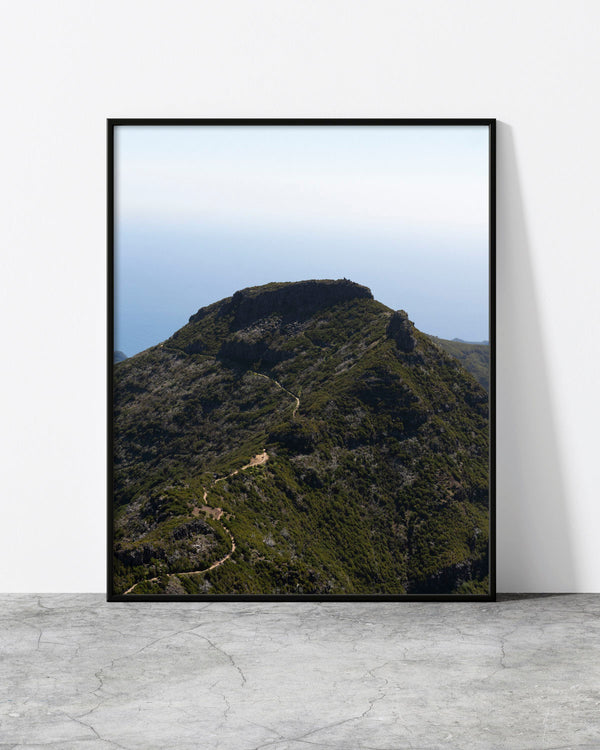 Mountain landscape print of a faint trail winding up a green volcanic peak under a pale sky, Madeira