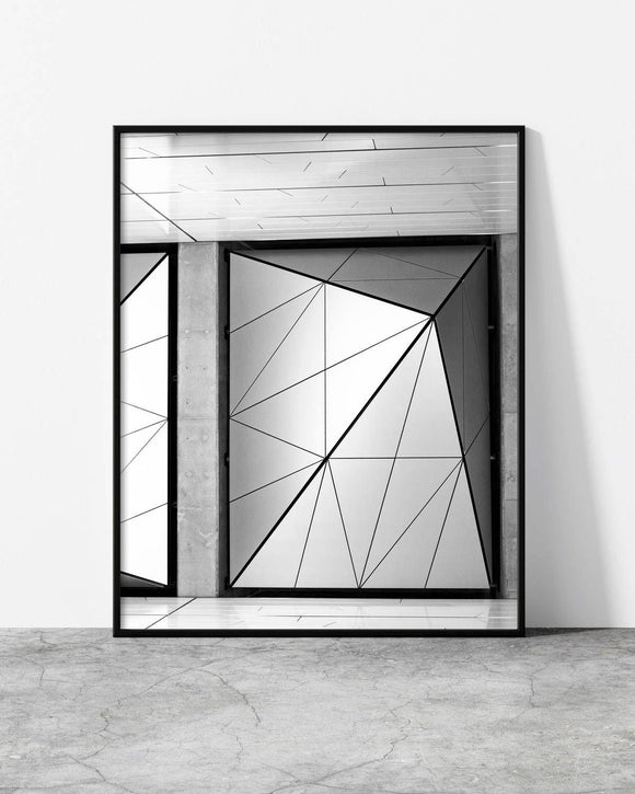 Minimalist black and white architectural photo featuring geometric steel panels framed by raw concrete and clean lines.
