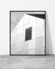 Minimalist black and white architectural photograph featuring a modern angular building facade with a single window.